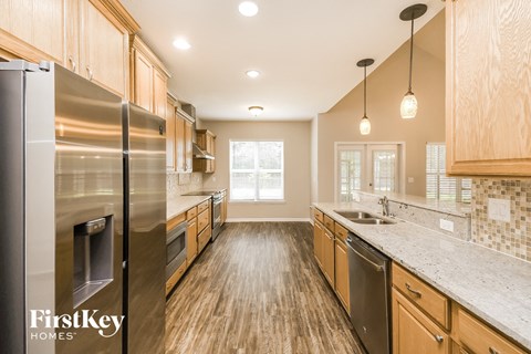 A kitchen with wooden cabinets and a stainless steel refrigerator.