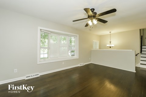 a living room with wood floors and a ceiling fan