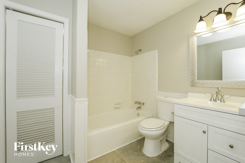 a white bathroom with a white toilet and tub and a sink