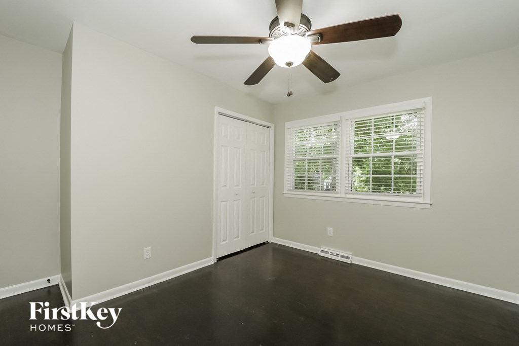 a empty room with a ceiling fan and a window
