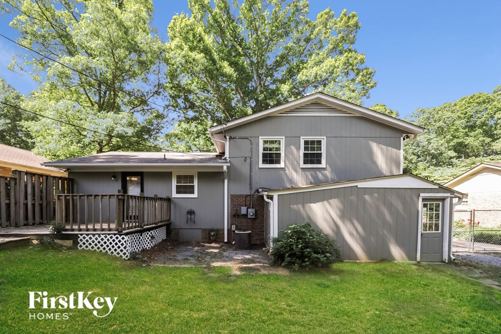 a gray house with a yard and a deck