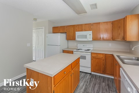 a kitchen with wooden cabinets and white appliances and a white stove and refrigerator