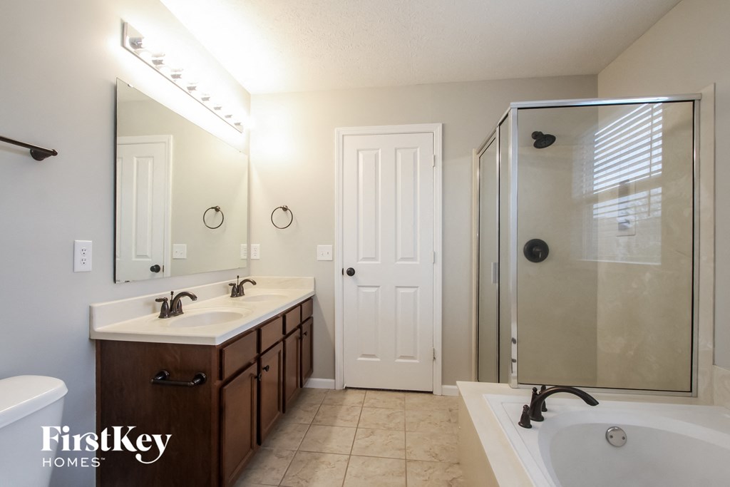 a bathroom with a tub and a sink and a shower