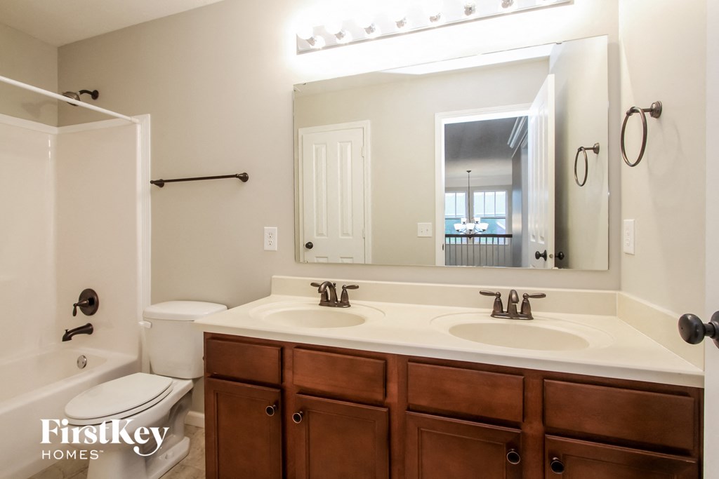 a bathroom with a large mirror and a sink and a toilet