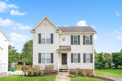 A two-story house with a front porch and a small front yard.
