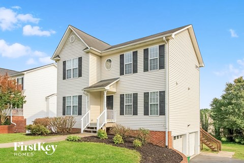 A two-story house with a front porch and a garage.