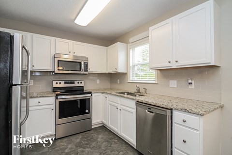 A kitchen with white cabinets and stainless steel appliances.