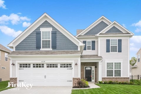 a white house with blue siding and a white garage door