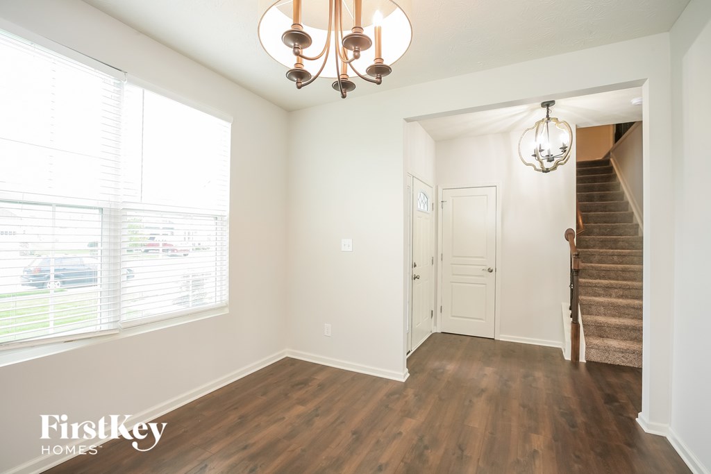 a living room with a staircase and a large window