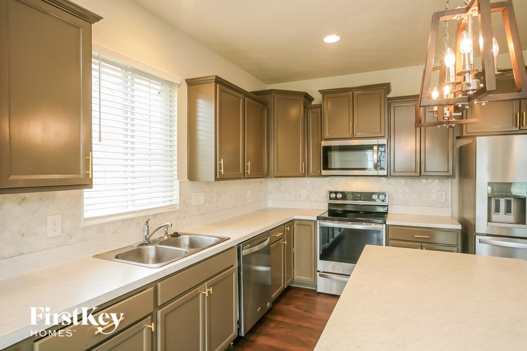 a kitchen with stainless steel appliances and white counter tops