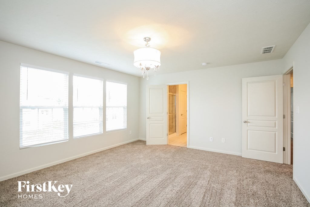 a master bedroom with a carpeted floor and large windows