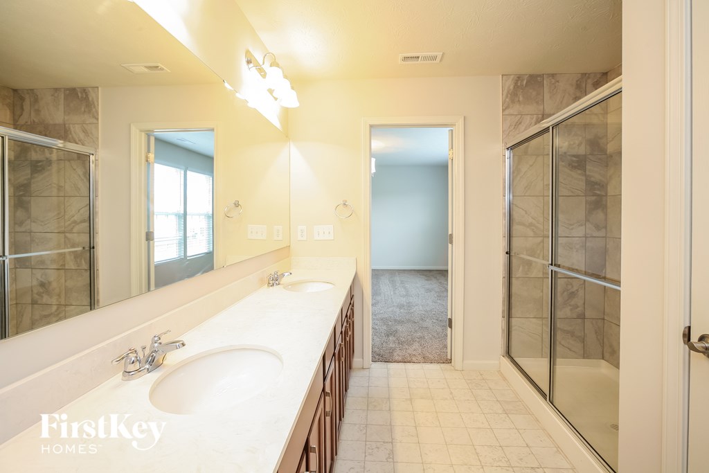 a bathroom with two sinks and a walk in shower