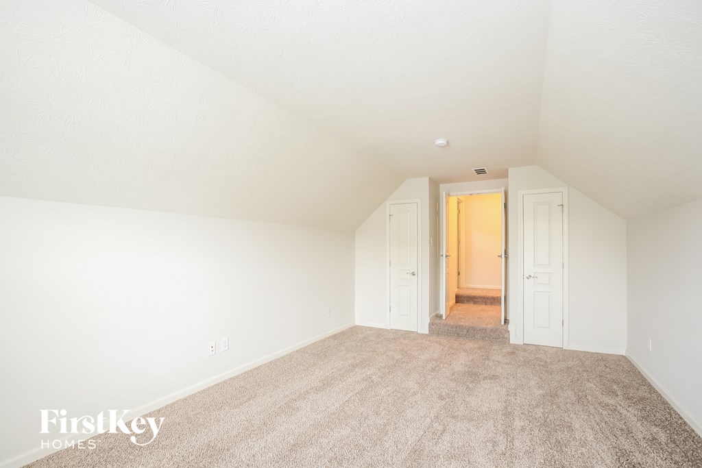 a spacious living room with carpeting and white walls