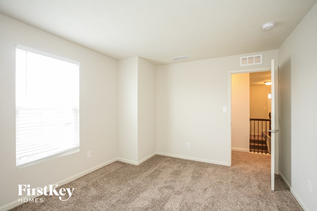 a spacious living room with carpet and a large window