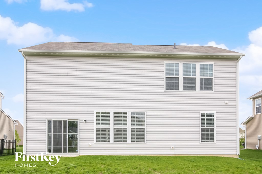 the front of a white house with white siding and grass