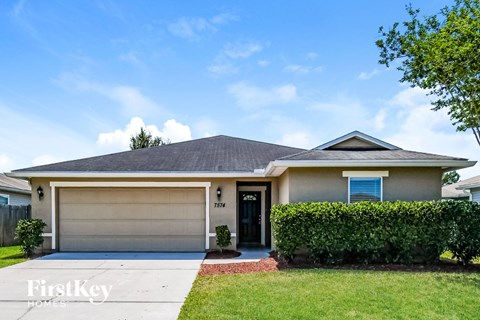 A house with a garage and a driveway in front.