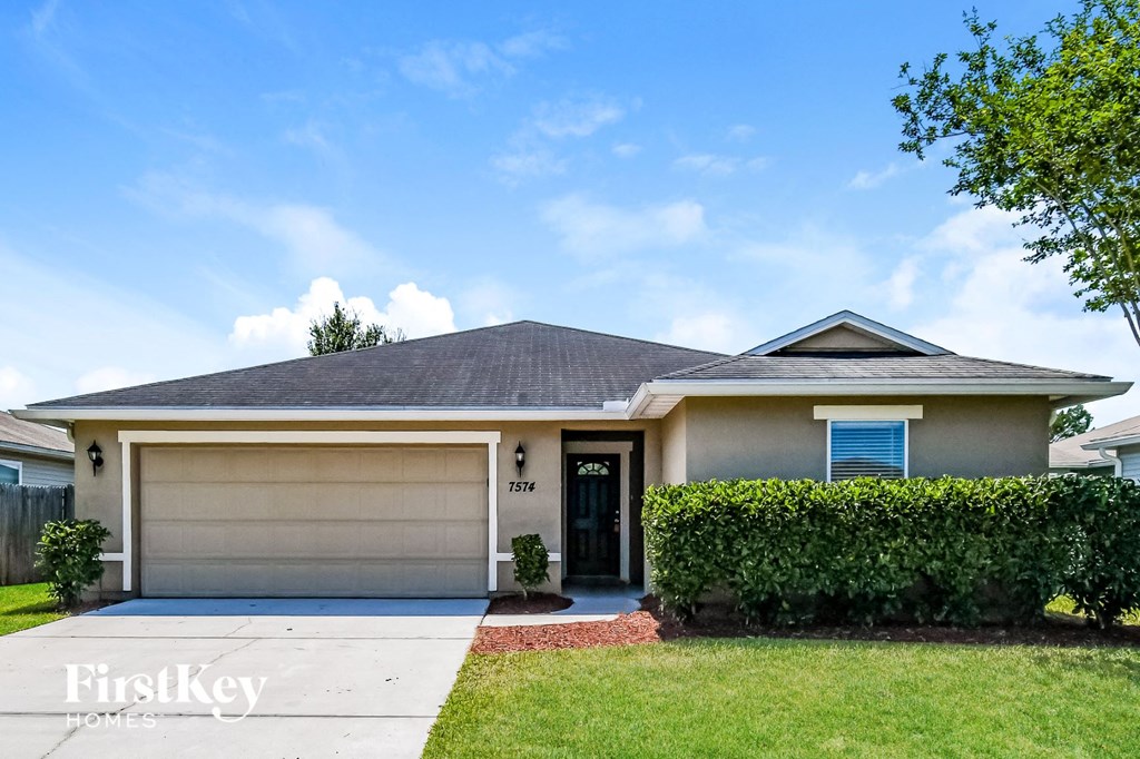 A house with a garage and a driveway in front.