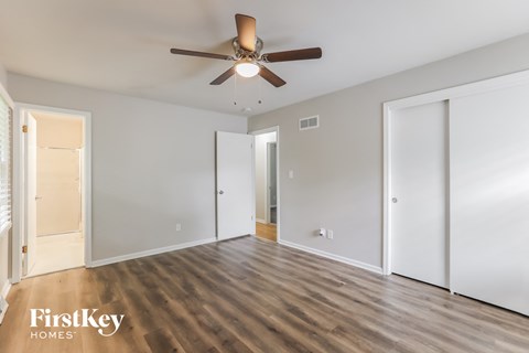 a living room with white walls and a ceiling fan
