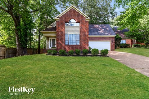 a home with a lawn and a white garage door