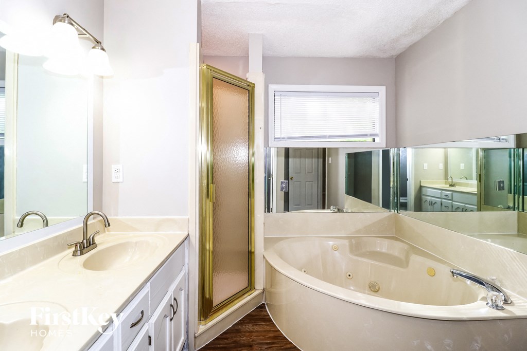 a bathroom with a large tub and a shower and a sink