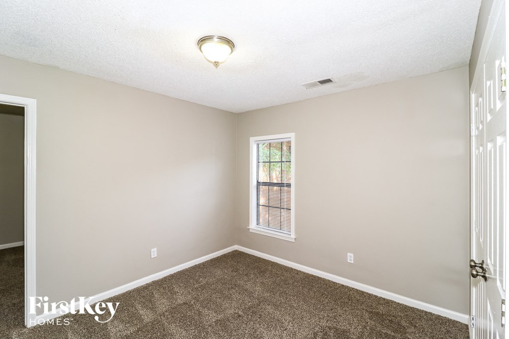 an empty room with carpet and a window