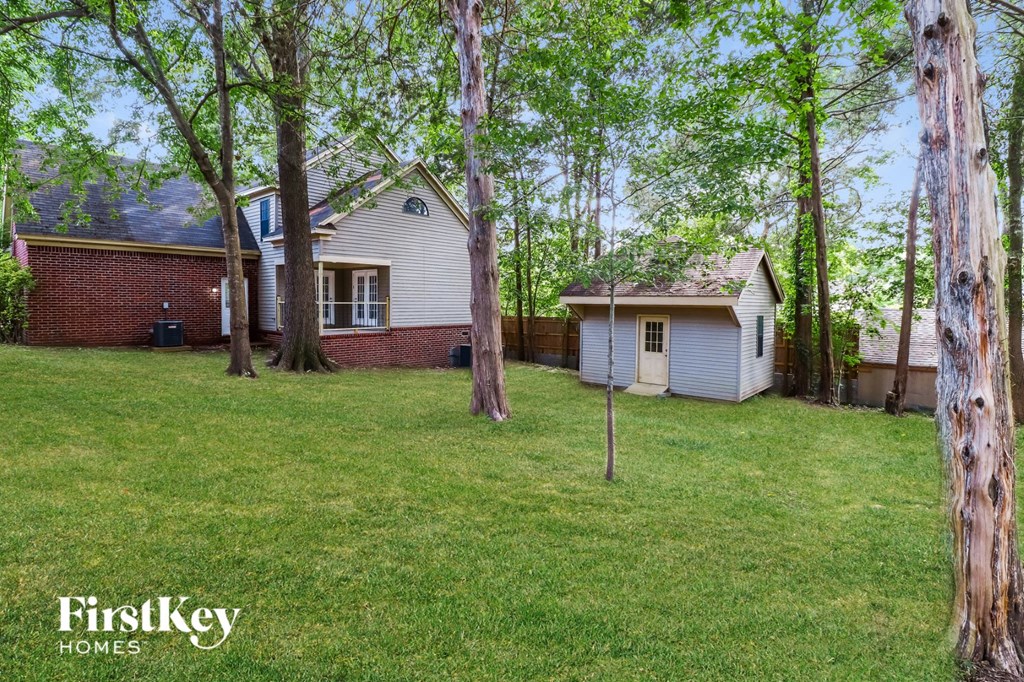 a white house with a yard and trees in front of it