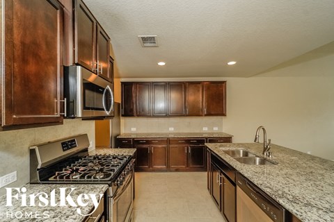 A kitchen with wooden cabinets and a granite countertop.