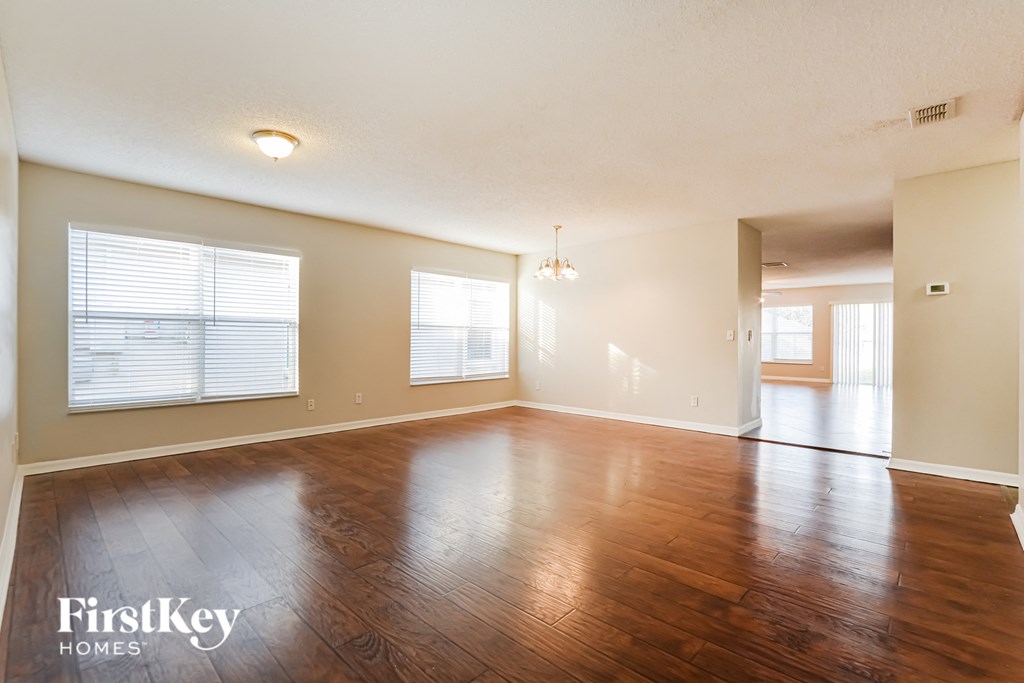 the living room and dining room of an empty house with wood floors