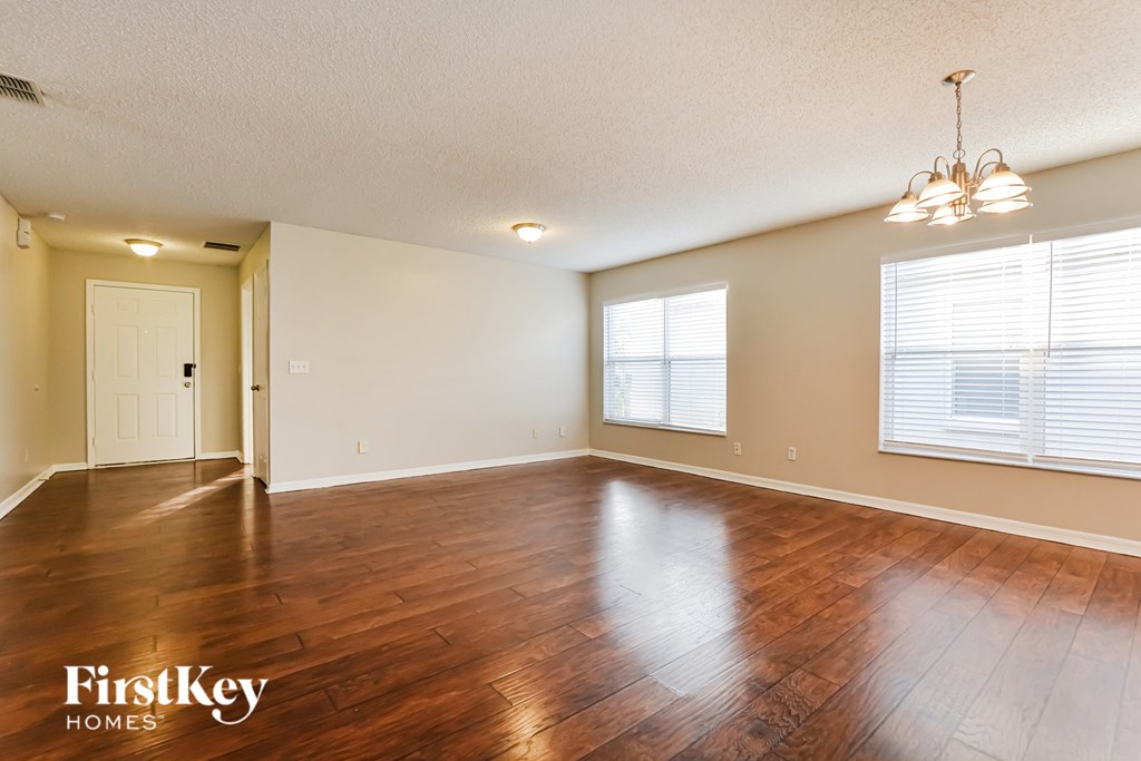 the living room and dining room of an empty house with wood floors
