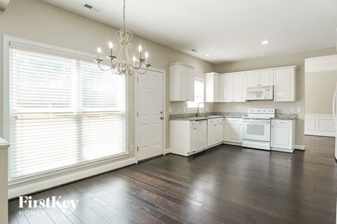 a large kitchen with white appliances and white cabinets