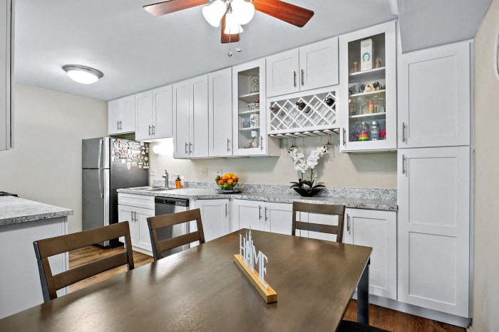 a kitchen and dining room with white cabinets and a table