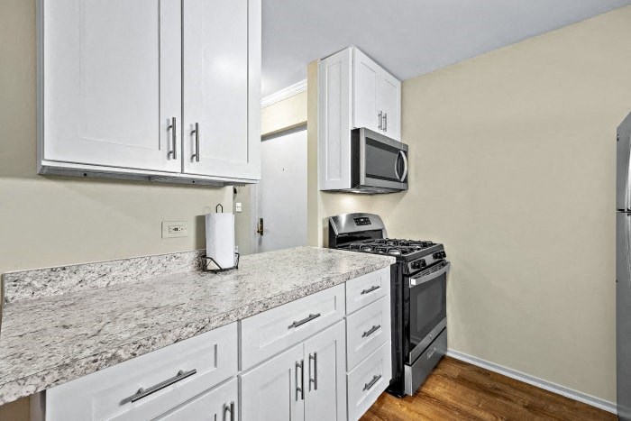 a kitchen with white cabinets and a stove and a microwave