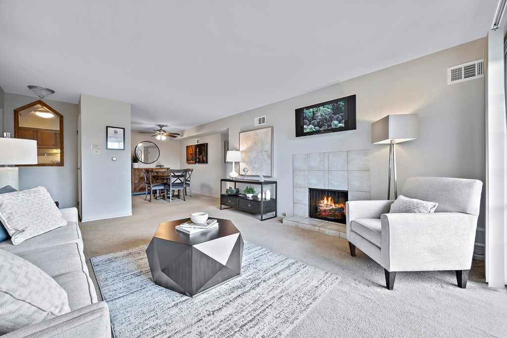 a living room with couches and a coffee table and a fireplace