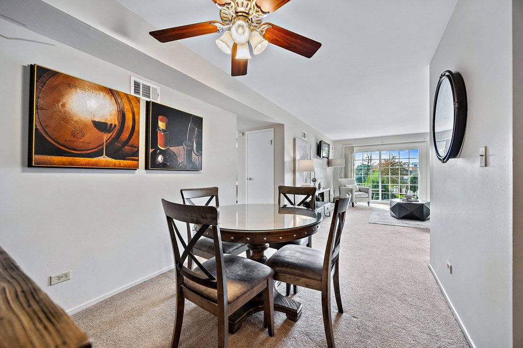 a dining room with a table and chairs and a ceiling fan