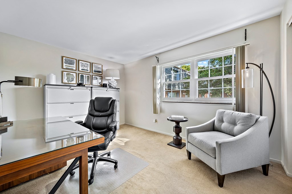 a home office with a desk and chair and a window