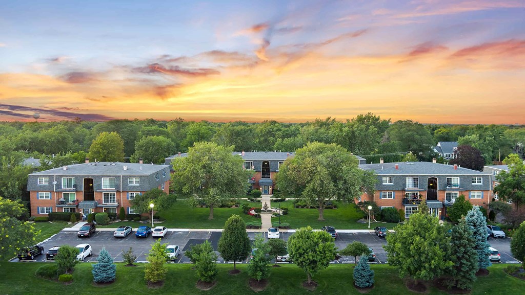 an aerial view of an apartment complex with a sunset in the background