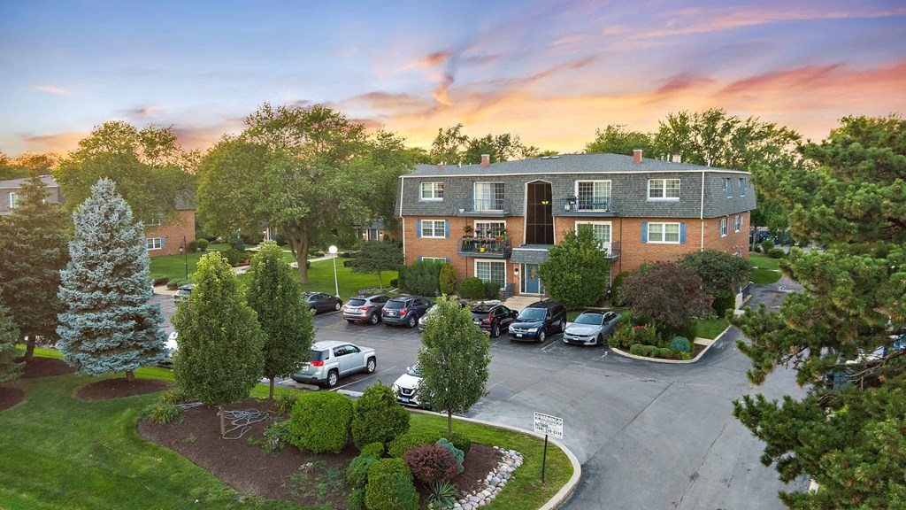 an aerial view of a house with cars parked in front of it