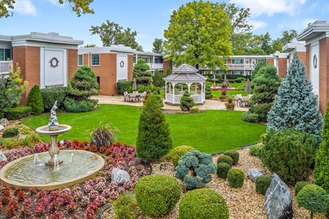 A garden with a fountain and a gazebo.
