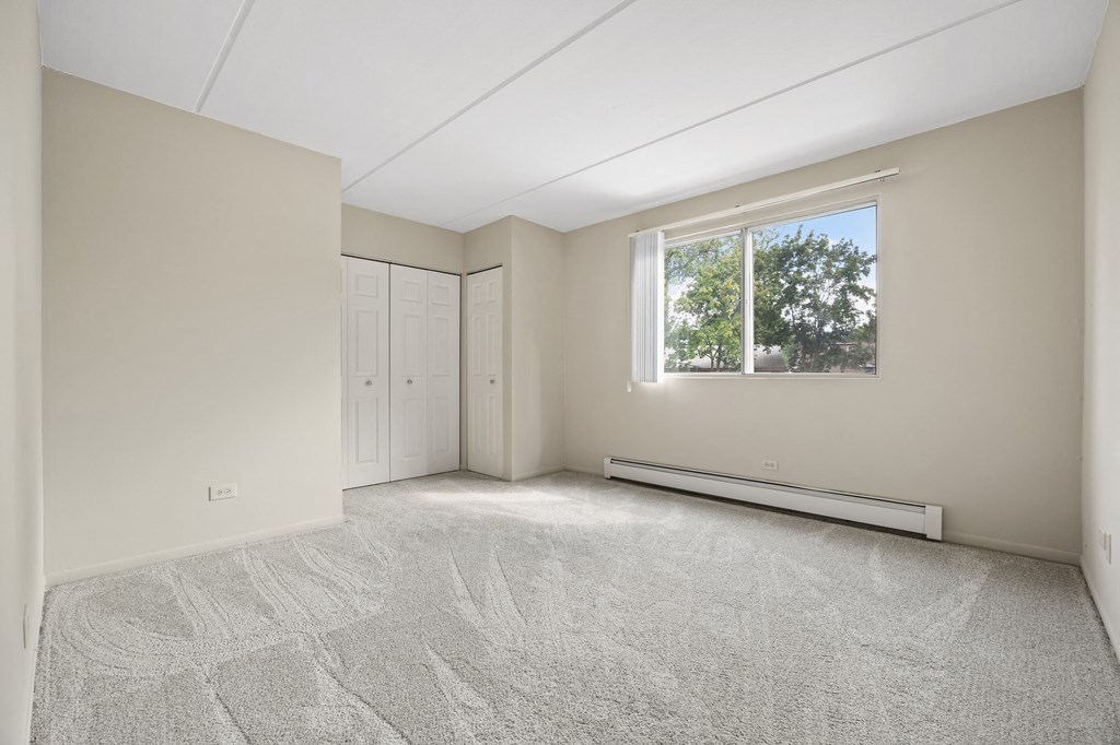an empty room with white walls and a window