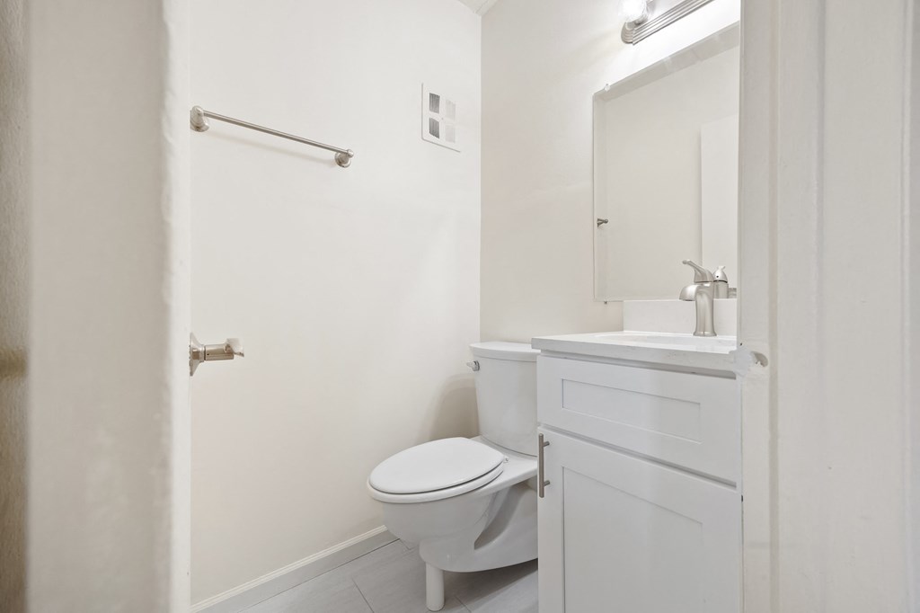 a white bathroom with a toilet and a sink