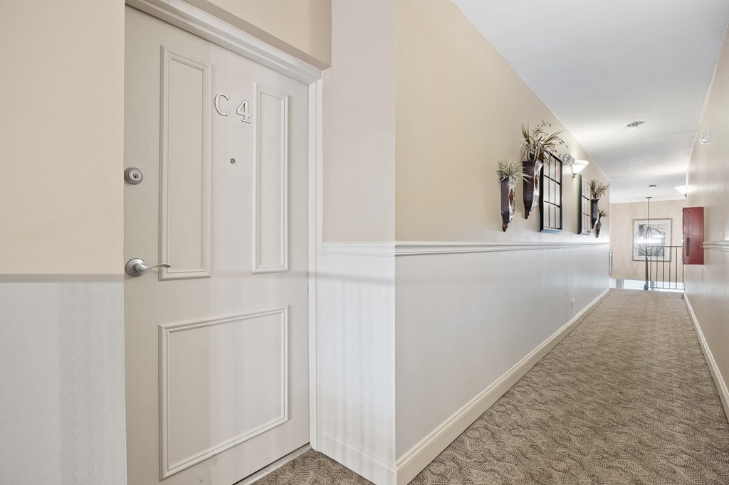 a hallway with white walls and white doors and a carpeted floor