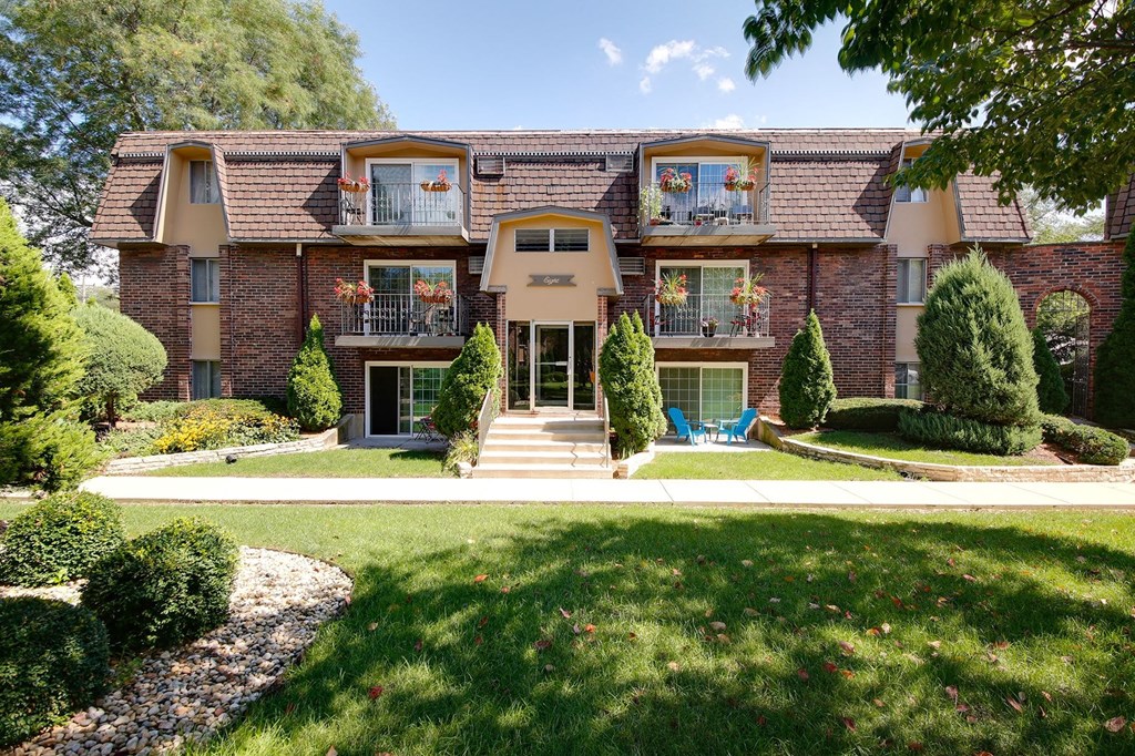 a large brick house with a lawn in front of it