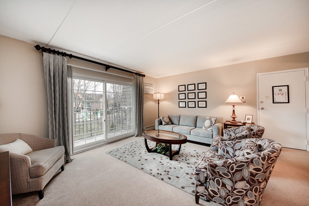a living room with couches and chairs and a sliding glass door