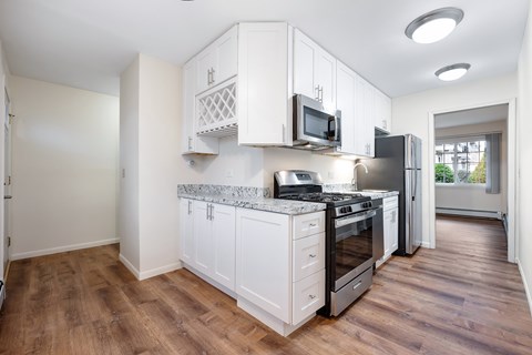A kitchen with white cabinets and a granite countertop.