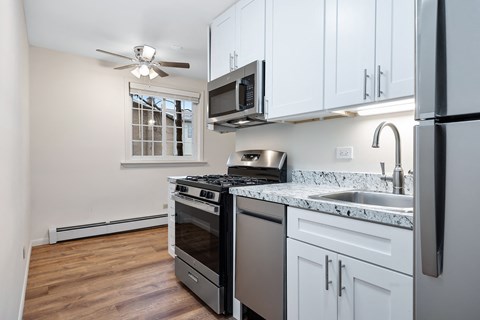 a kitchen with white cabinets and stainless steel appliances