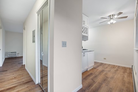 A room with a ceiling fan and a white cabinet.