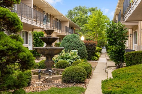 A fountain in the middle of a well-manicured garden.