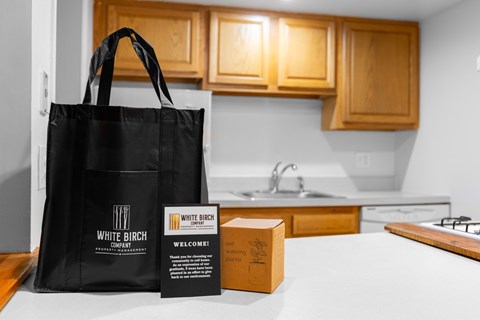 A black bag with the words White Birch Company on it is on a kitchen counter.
