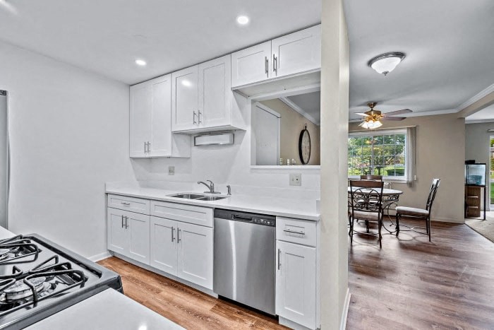 a kitchen with white cabinets and a stove and a sink
