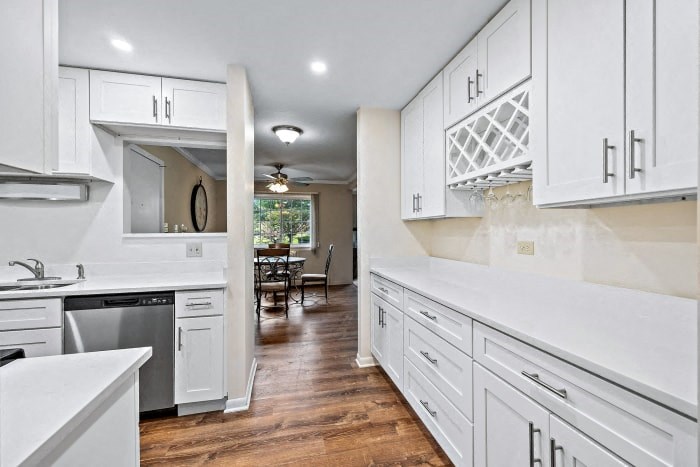 a large white kitchen with white cabinets and stainless steel appliances